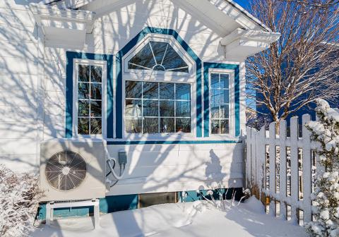 11air source heat pump outside of a snowy home window