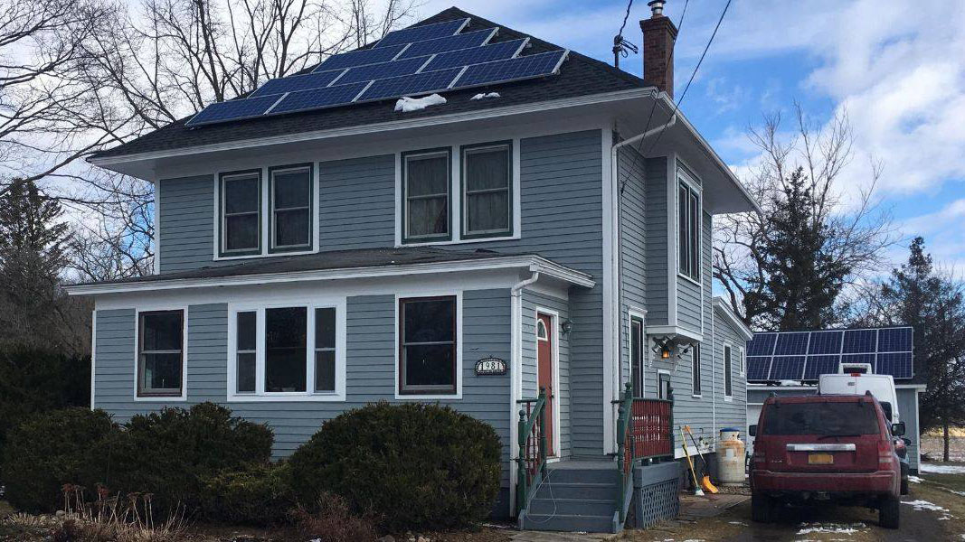 11A house with solar panels on the roof and in the back yard